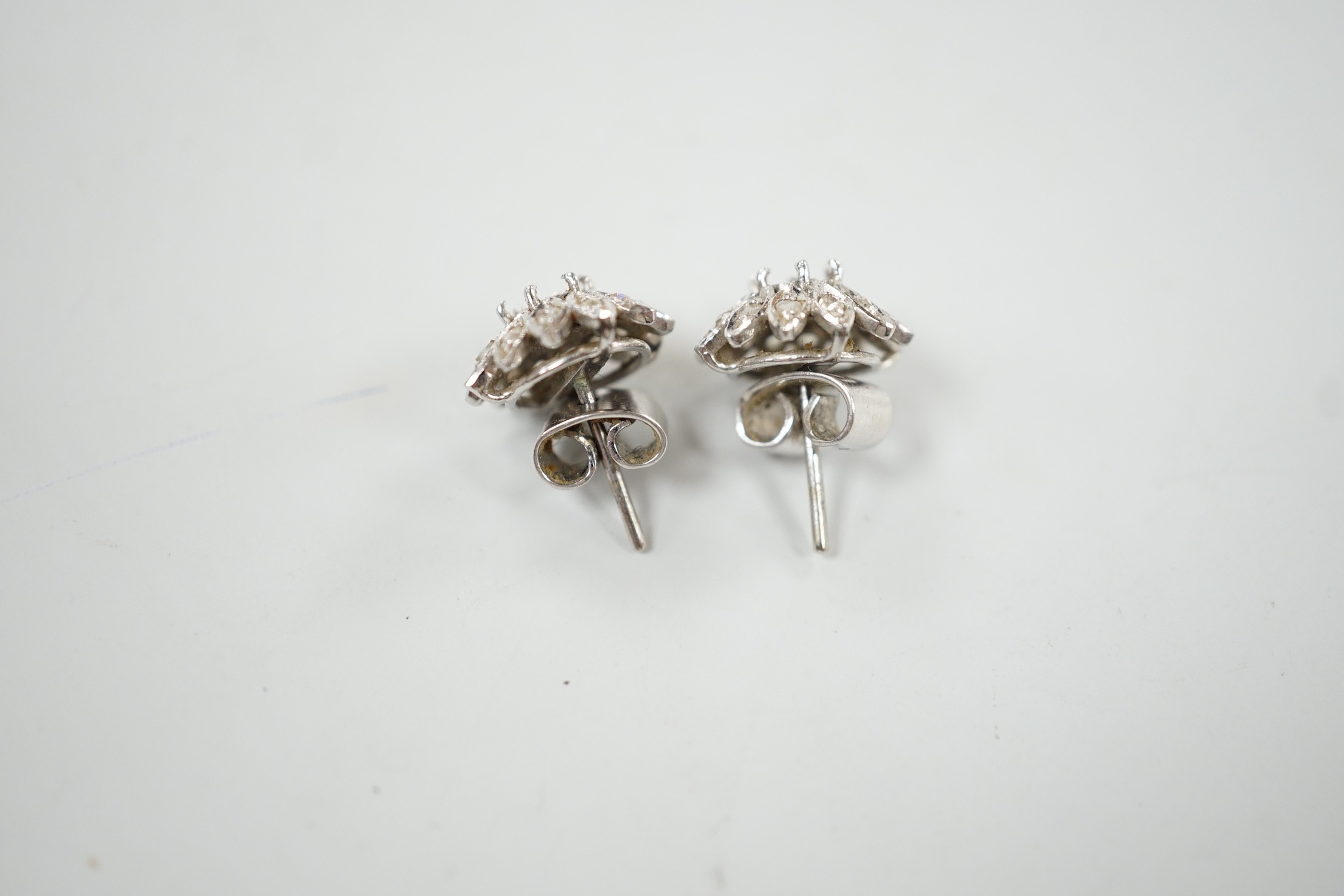 A cased pair of white metal and diamond cluster set flower head ear studs, both lacking centre stone, diameter 13mm, gross weight 4.4 grams.